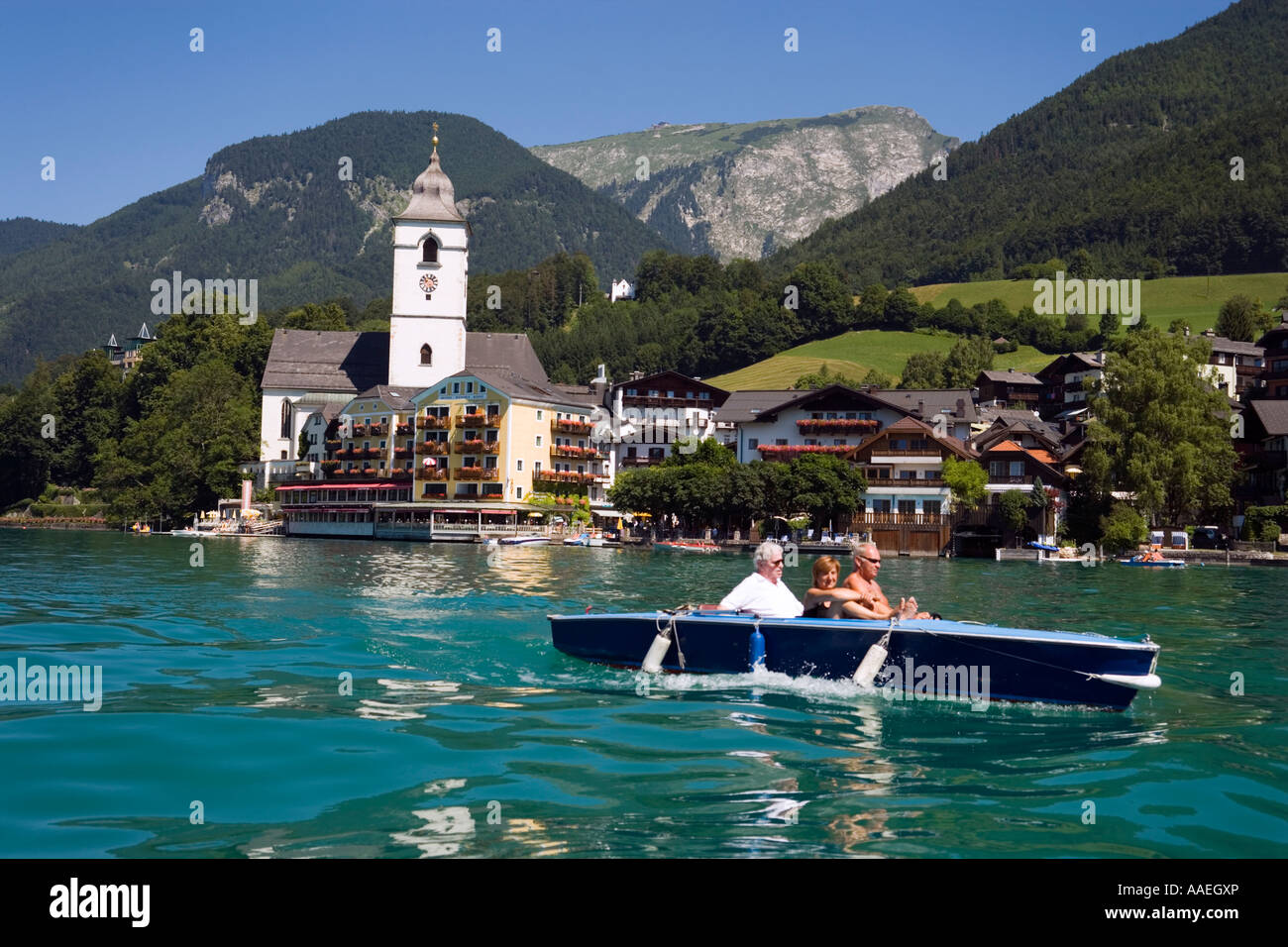 Wolfgangsee Hotel Im Weissen Rossel am Wolfgangsee people in an electric boat passing St Wolfgang Upper Austria Salzkammergut Stock Photo