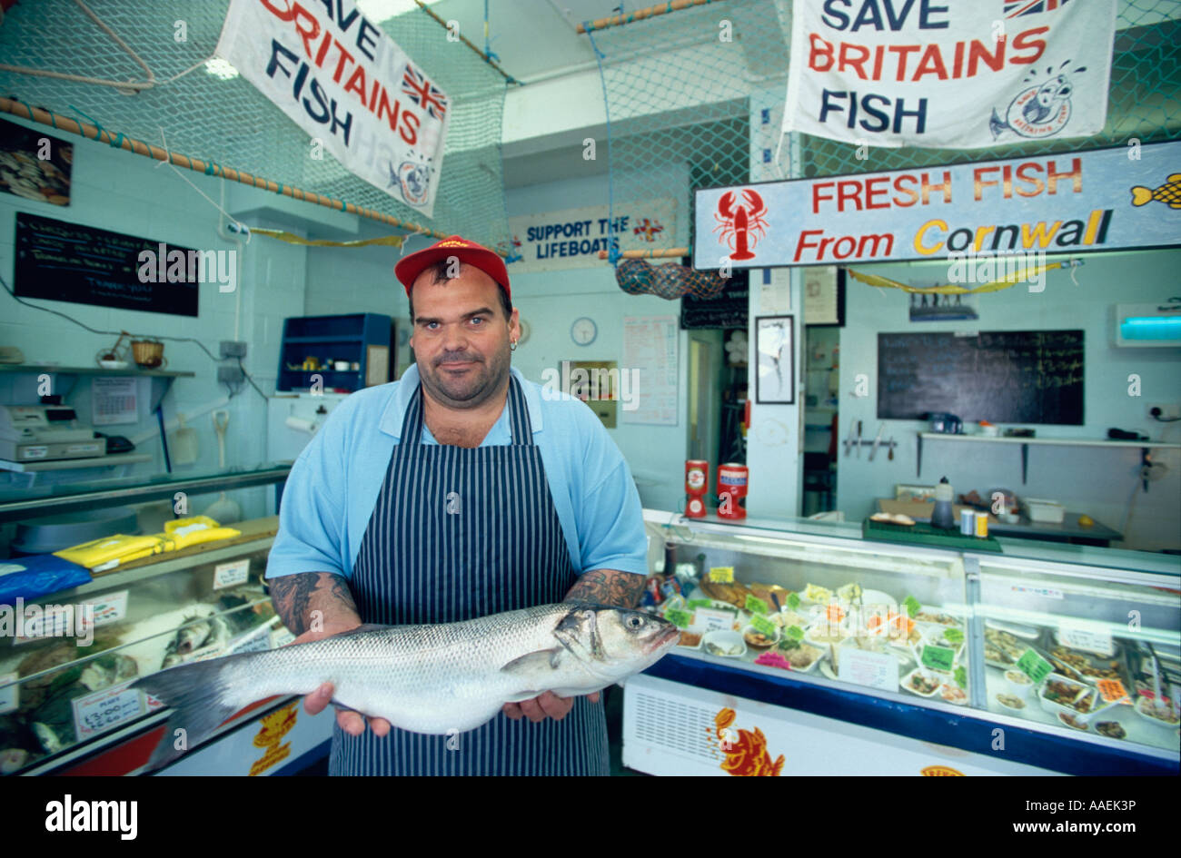 Fishmonger presenting a catch in his shop protesting against ...
