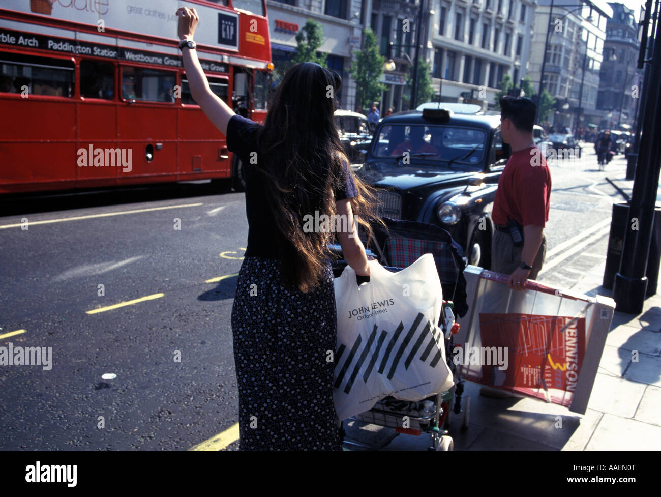 Woman hailing a taxi Oxford Street London London England United Kingdom Stock Photo