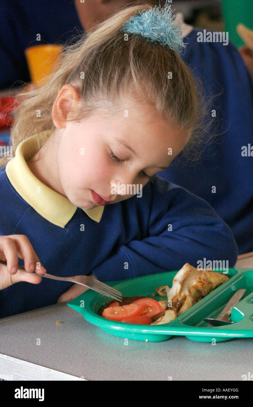 Primary school girl in canteen eating lunch Stock Photo Alamy