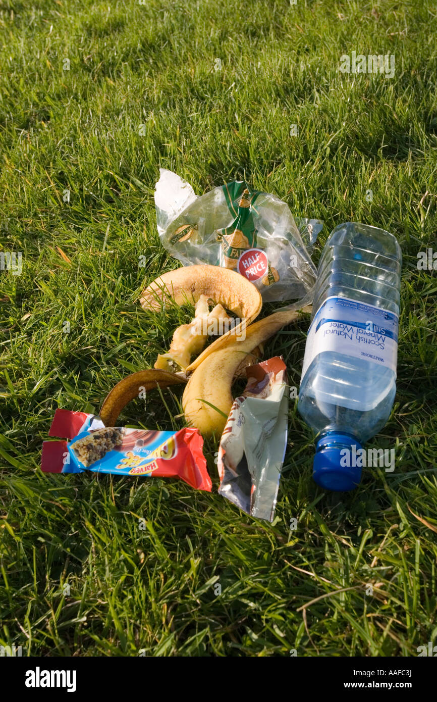 Discarded picnic litter and plastic packaging rubbish dumped on grass UK Stock Photo