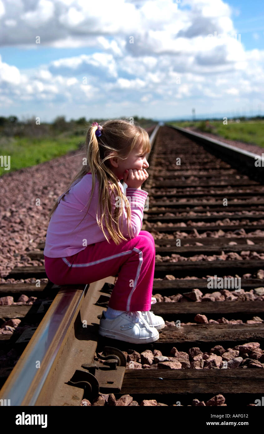 Girl sittiing on railroad tracks Stock Photo Alamy