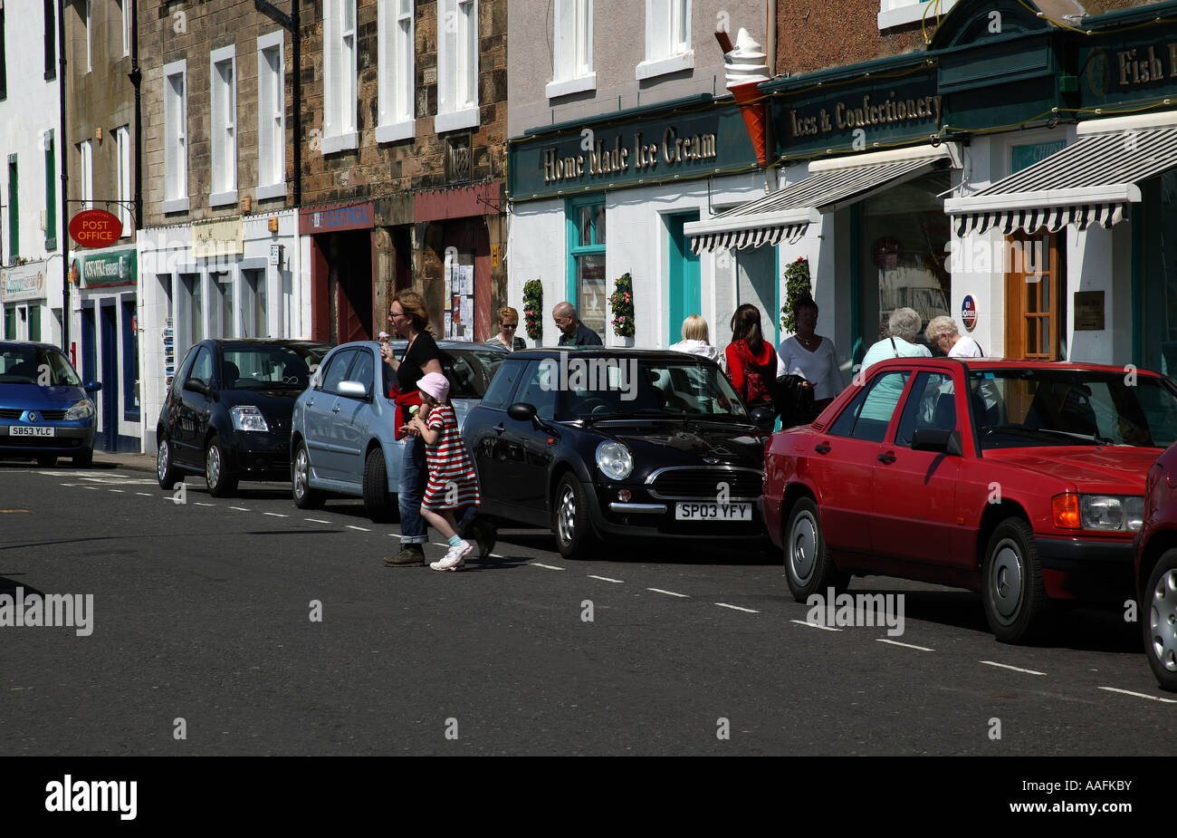 Anstruther High Street, Fife, Scotland Europe with pedestrians crossing and vehicles parked Stock Photo