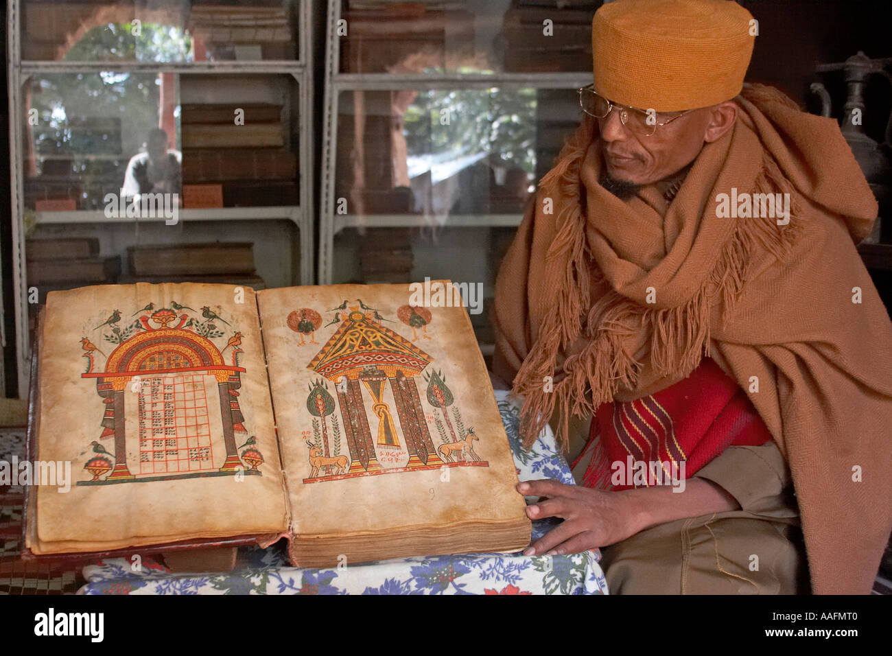 Monk showing old 1555 illuminated manuscript parchment book of gospels