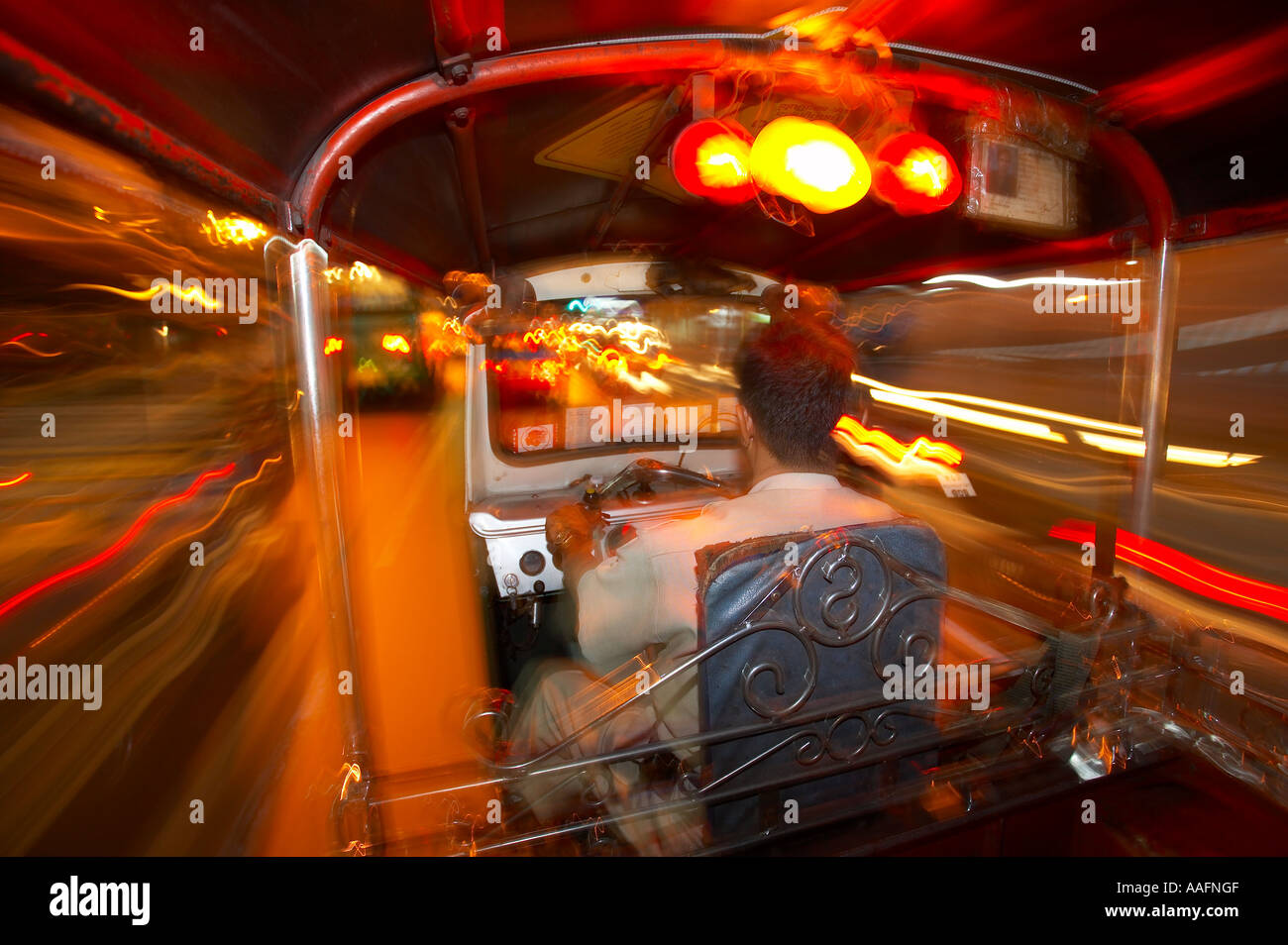 in the back of a tuk tuk at night at speed on the streets of Bangkok Thailand Stock Photo