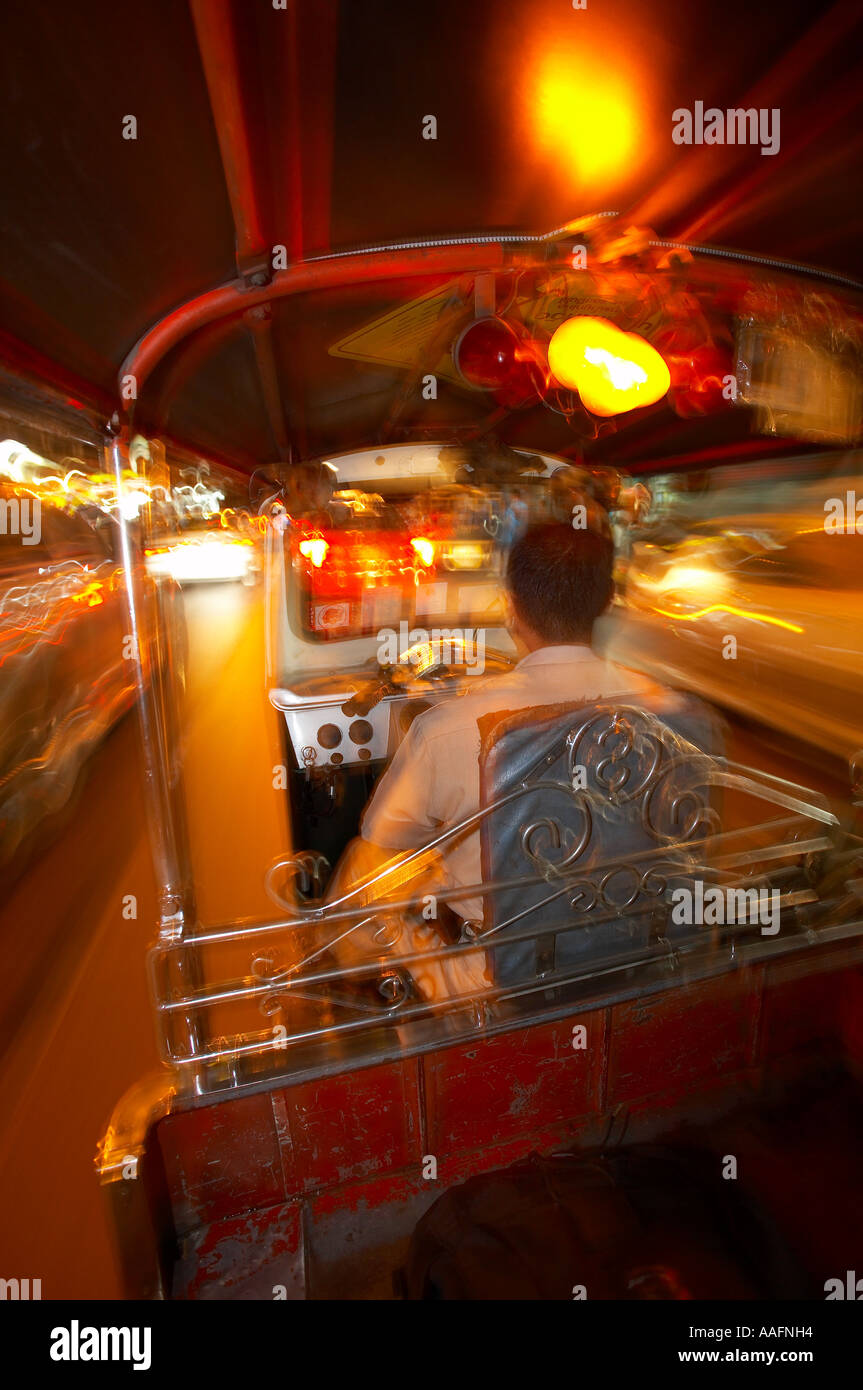 in the back of a tuk tuk at night at speed on the streets of Bangkok Thailand Stock Photo