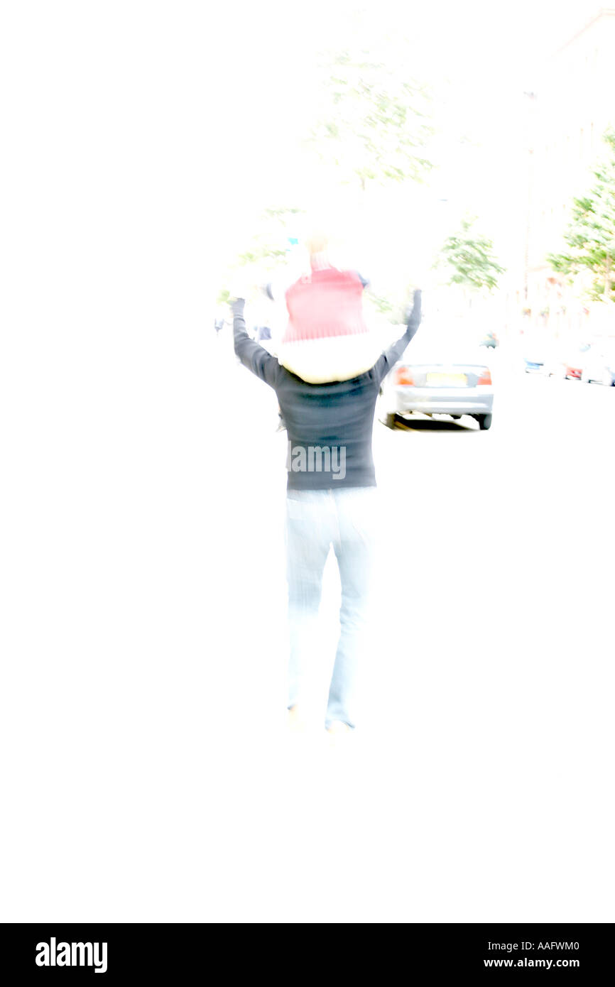 Abstract over exposed image of woman running carrying child on a street KMH CJWH Stock Photo