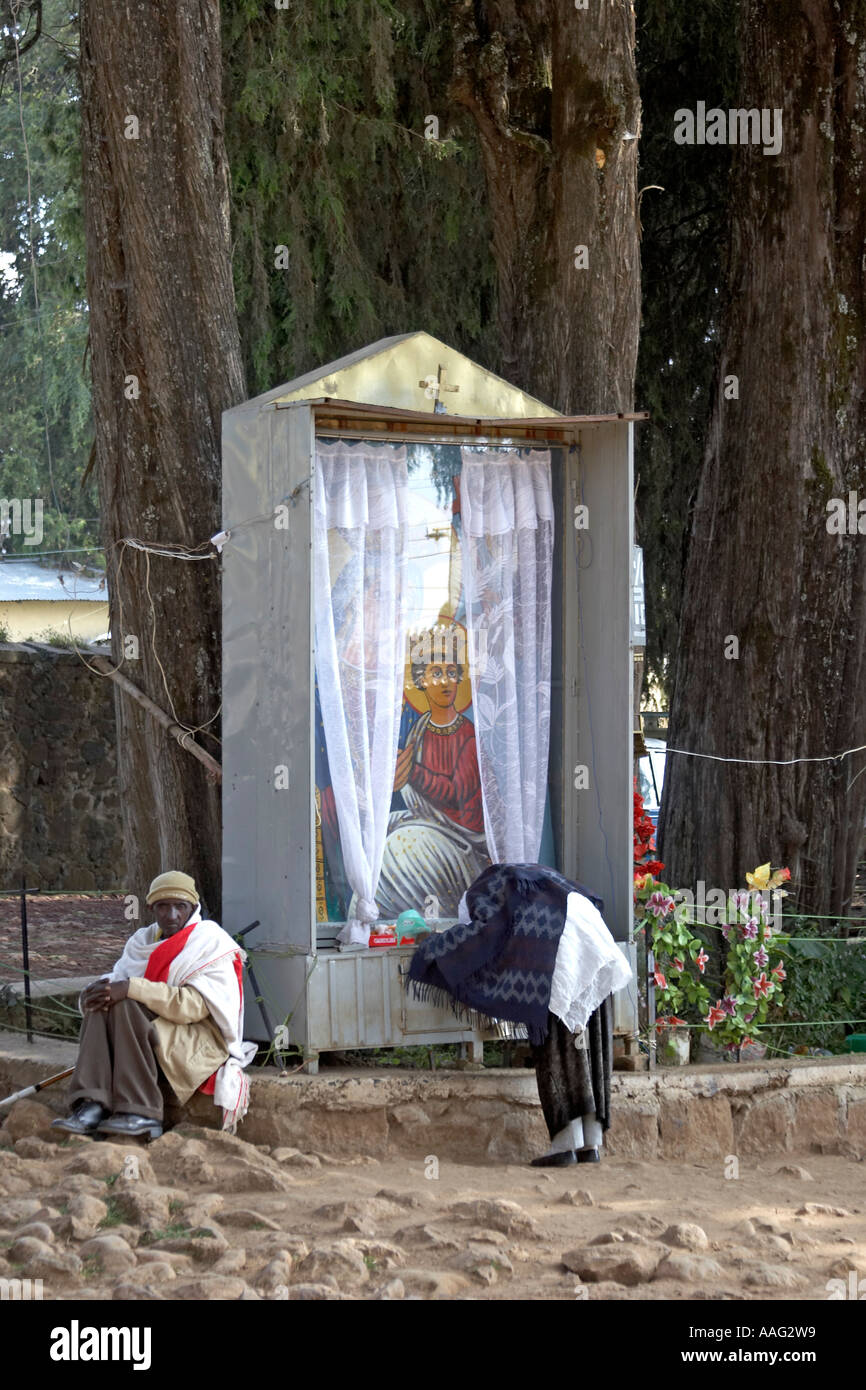 Woman praying at icon outside Entoto Maryam Ethiopian orthodox church above Addis Ababa Ethiopia Africa Stock Photo