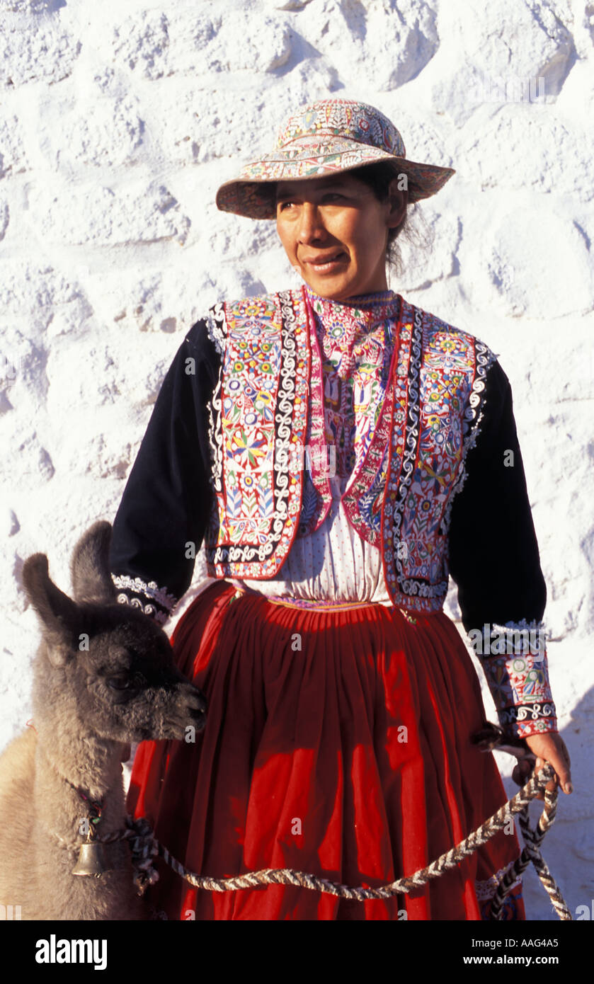 A Quechua woman from the Colca Valley in distinctive local costume with a 12 day old llama Nr Chivay Colca Canyon Peru Stock Photo