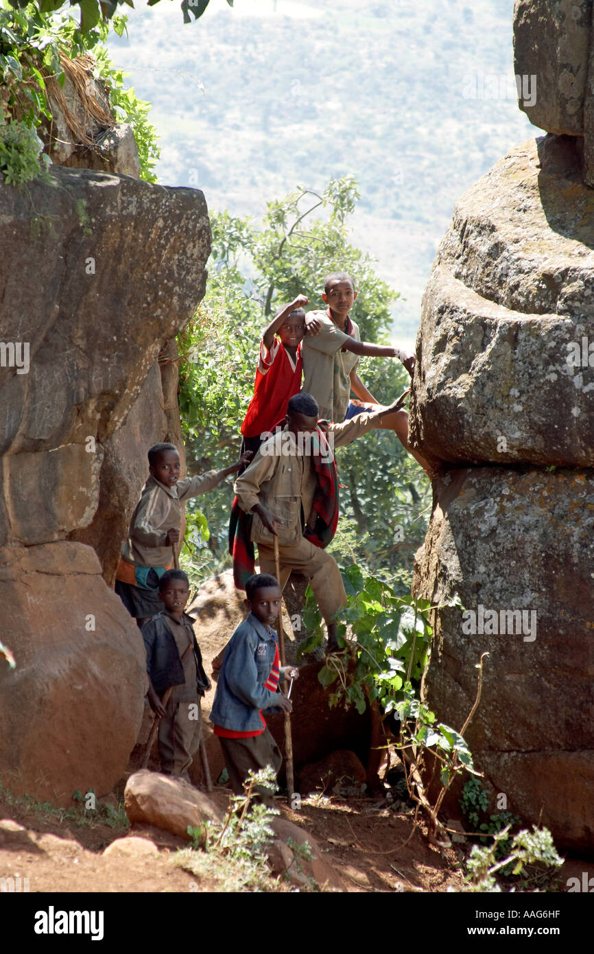 Young children playing posing standing on a stone between rocks with ...