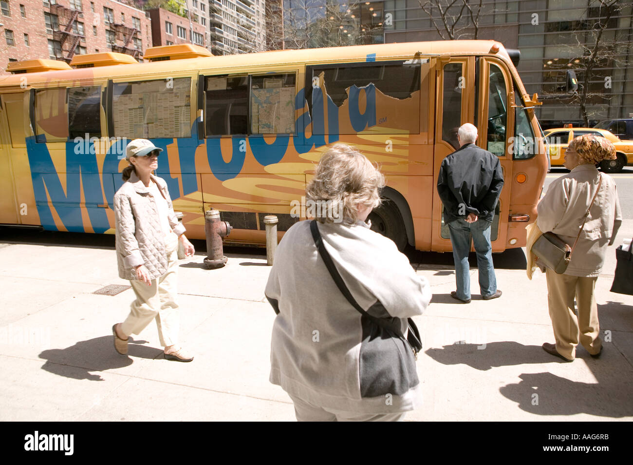 People wait to enter a Metrocard bus in a street in New York City USA April 2006 Stock Photo