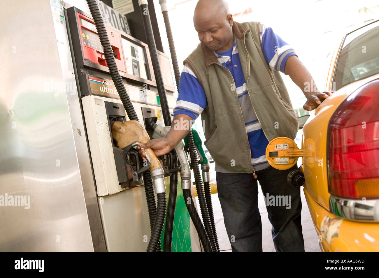 Filling up the yellow cab at a gas station in Harlem New York City USA ...