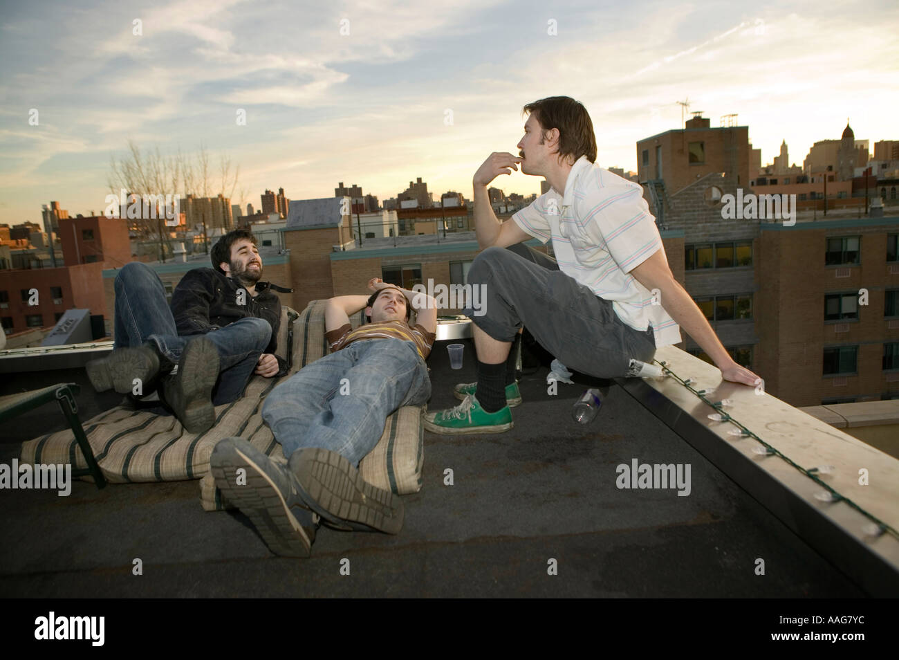 friends chat on a rooftop on a warm spring evening in New York City USA April 2006 Stock Photo