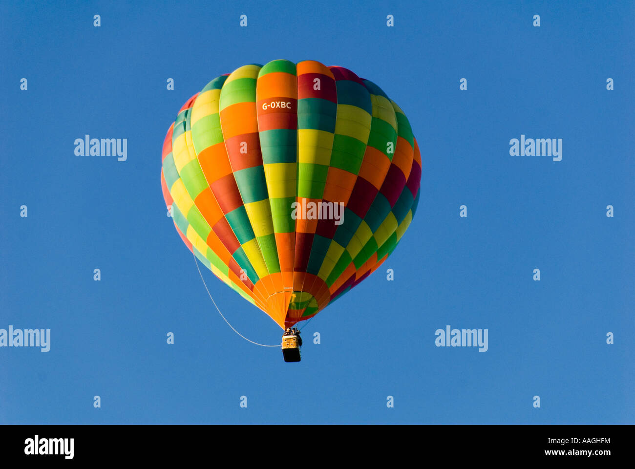 Multicoloured Hot Air Balloon floating in a Blue Sky Stock Photo - Alamy