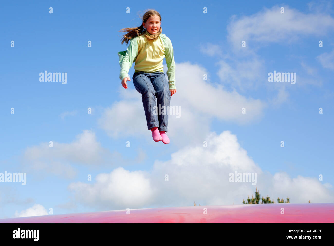 a young girl jumping on a big rubber trampoline Stock Photo