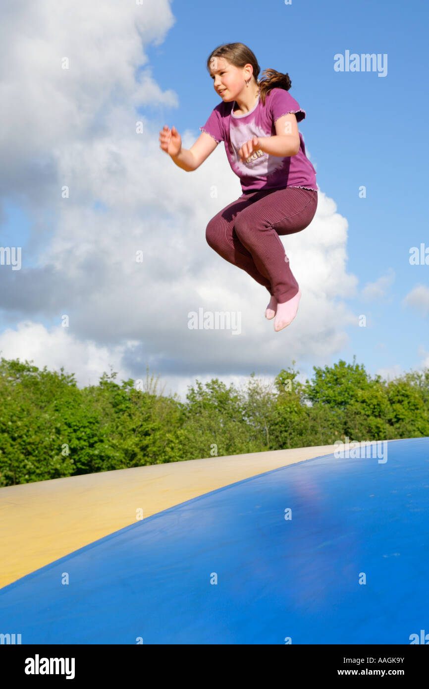 a young girl jumping on a big rubber trampoline Stock Photo Alamy