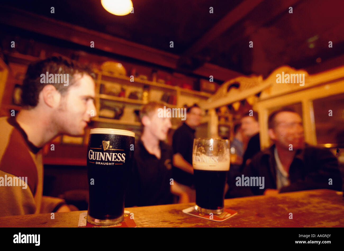 Men at Bar behind two glasses of Guinness in O Riadas Pub Parliament Street County Kilkenny Ireland Stock Photo