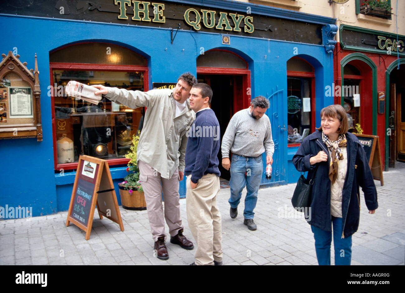 Man giving directions to annother man in front of Pub pedestrian area