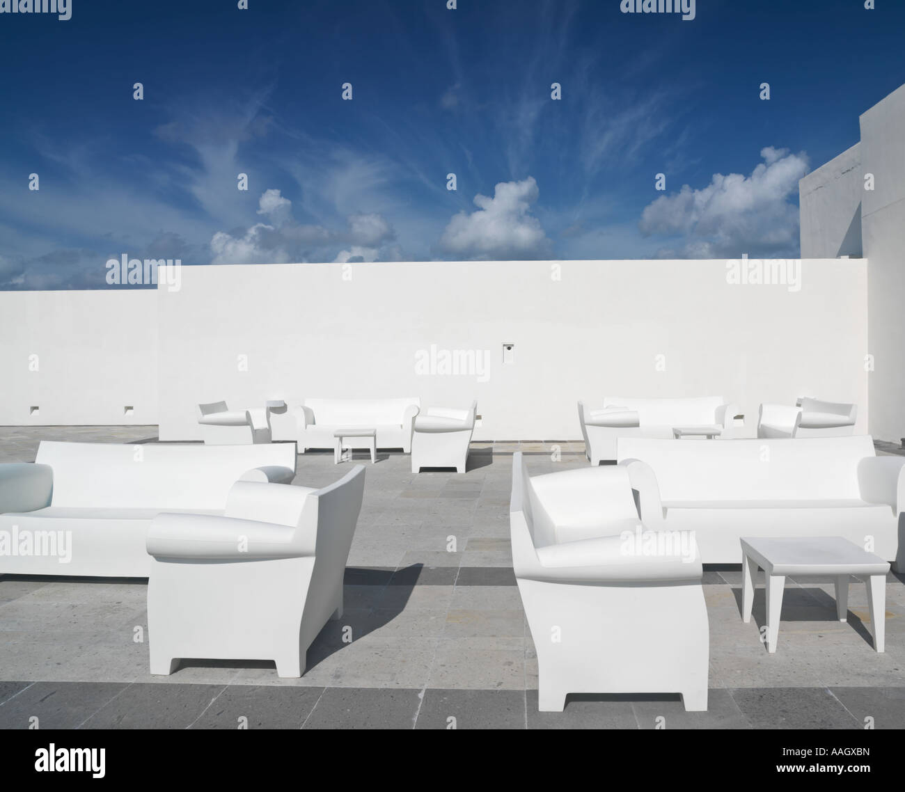 Mexico Quintana Roo Yucatan Peninsula Akumal Mayan Riviera white chairs and couches against a white wall and blue sky Stock Photo