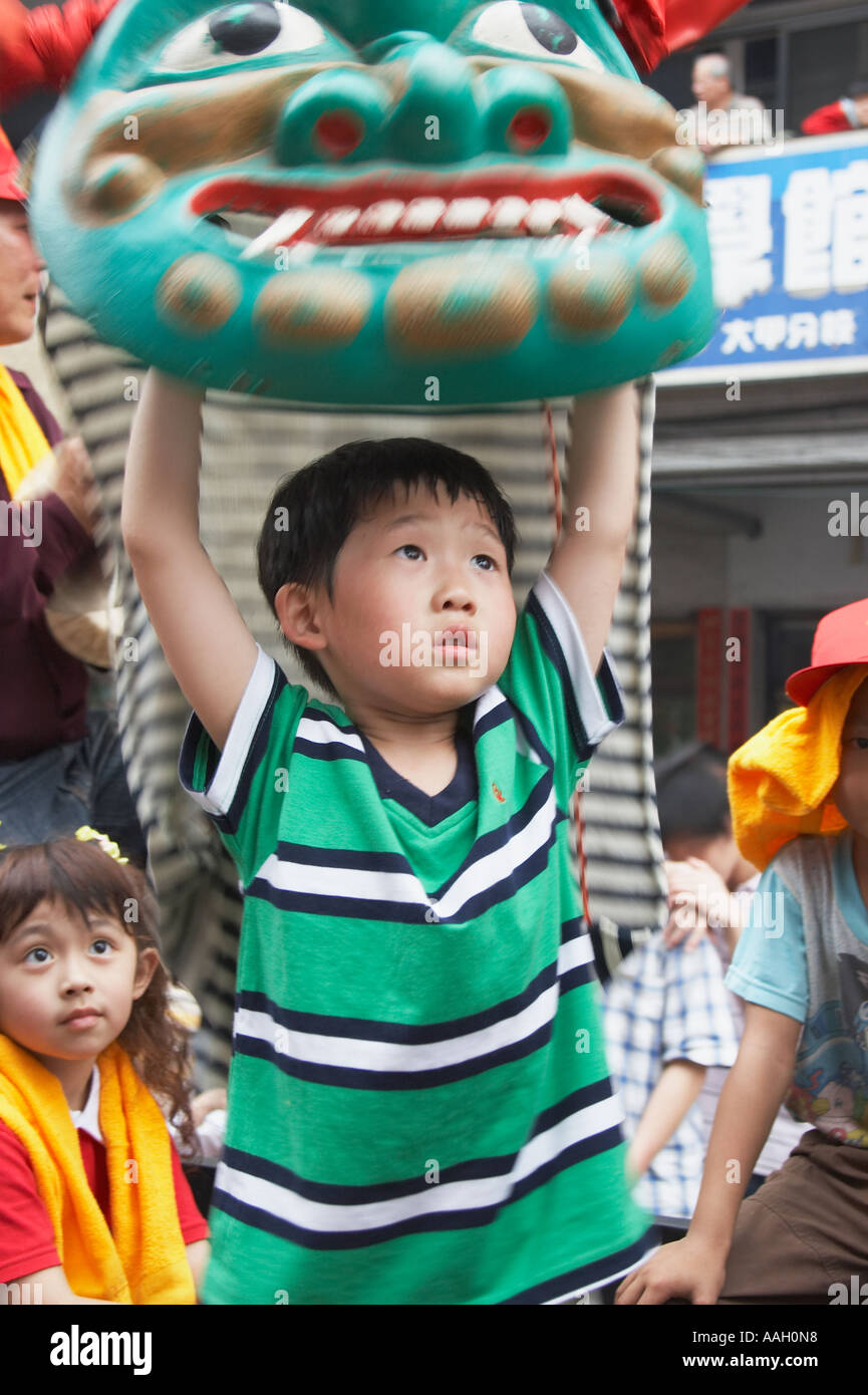 Boy Holding Up Chinese Dragon At Matsu Festival Stock Photo
