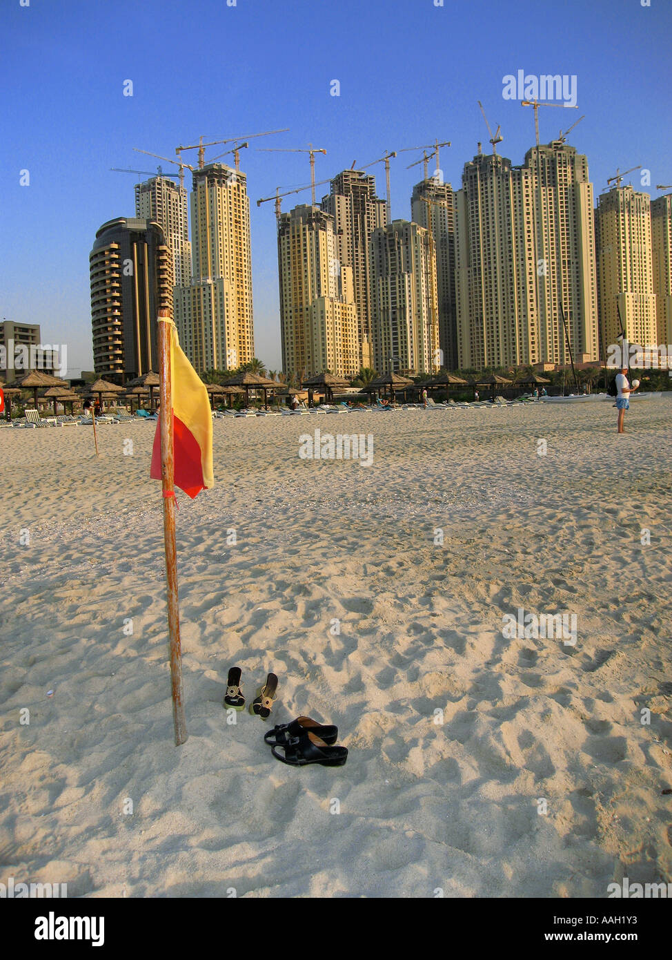 Construction of new high rise buildings in Jumeirah, Dubai, United Arab Emirates with beach in foreground with shoes Stock Photo