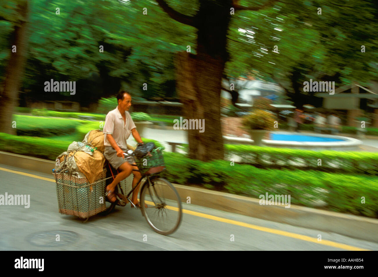 Man riding a bicycle in China cargo courier Stock Photo Alamy