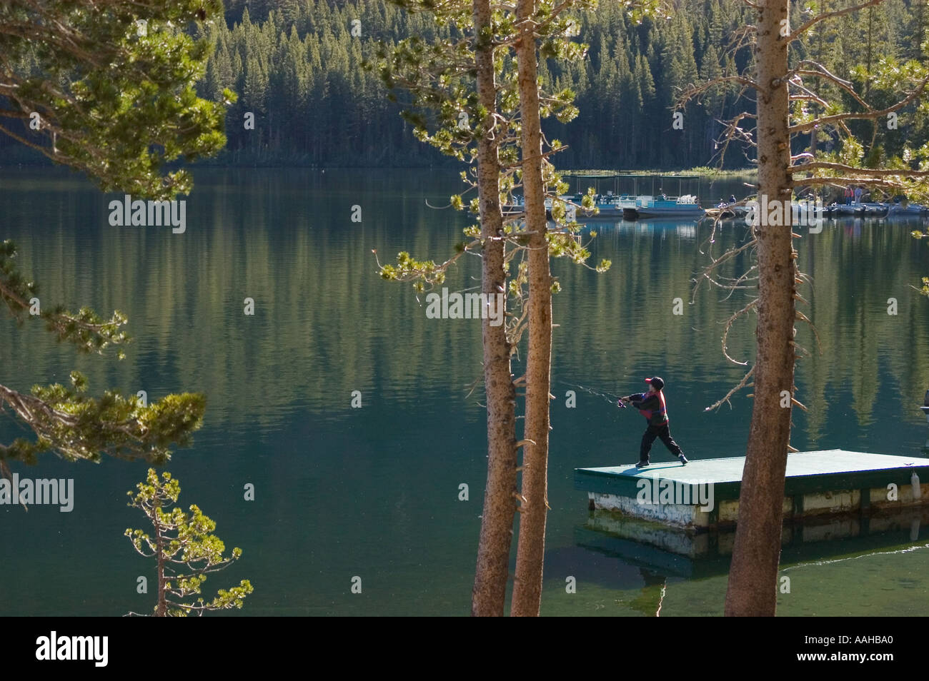 Boy fishing from dock in early morning at Lake Mary Mammoth Lakes