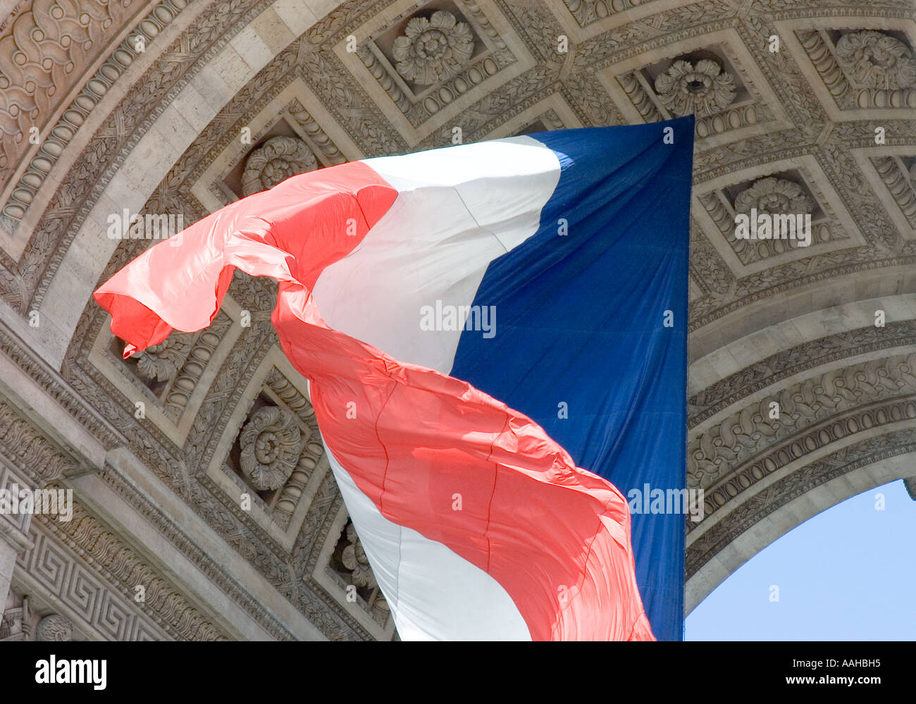 French tri-colour flying beneath the Arc de Triomphe in Paris, France Stock Photo