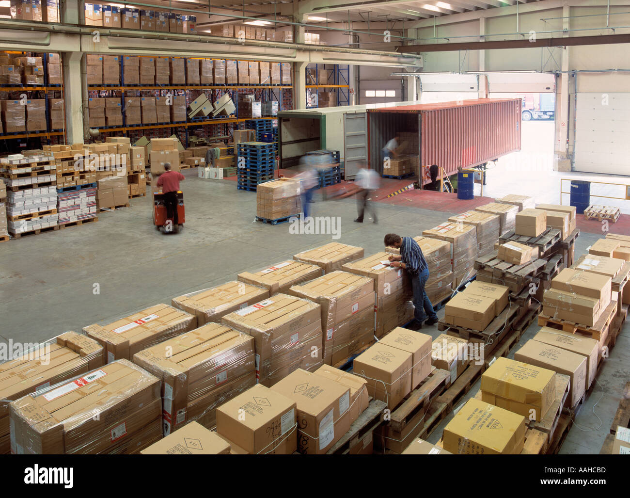 people loading containers in a warehouse Stock Photo