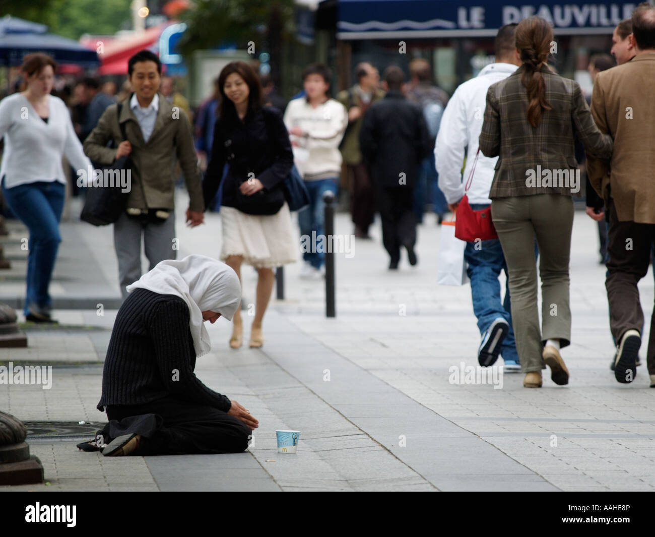 Woman begging on the Avenue des Champs Elysees Paris France Stock Photo