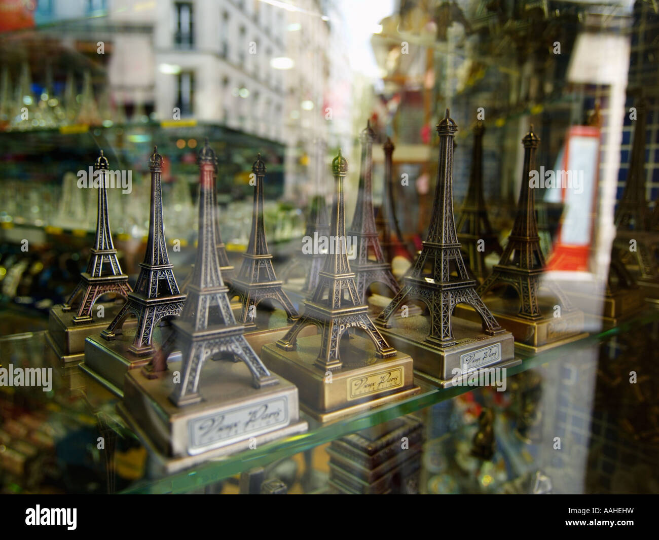 Little metal Eiffel towers on a shelf in the window of a souvenir shop