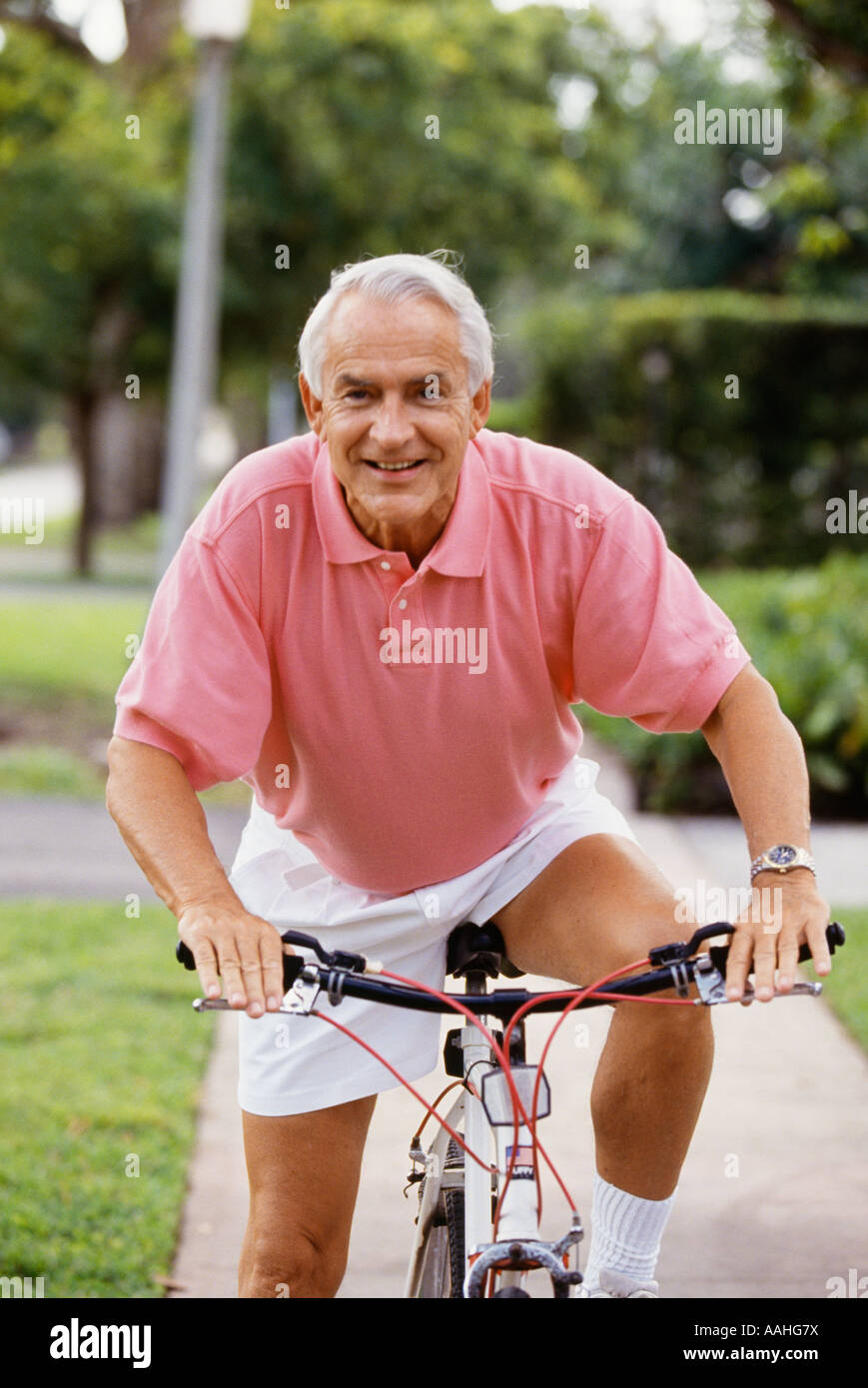 Senior man riding on bicycle smiling portrait Stock Photo