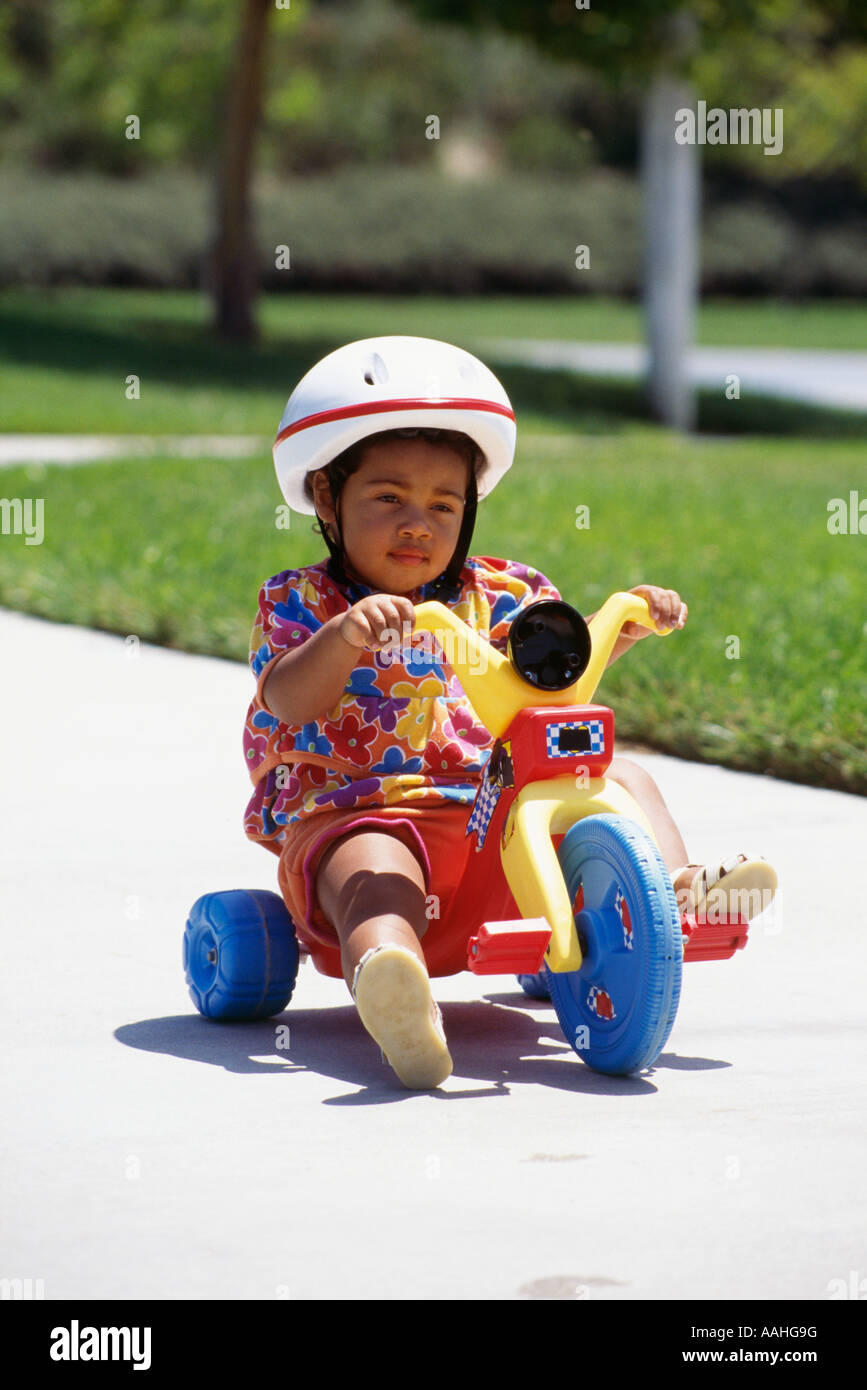 Girl child toddler pre-k  3 4 years year old  riding on tricycle big wheel POV Stock Photo