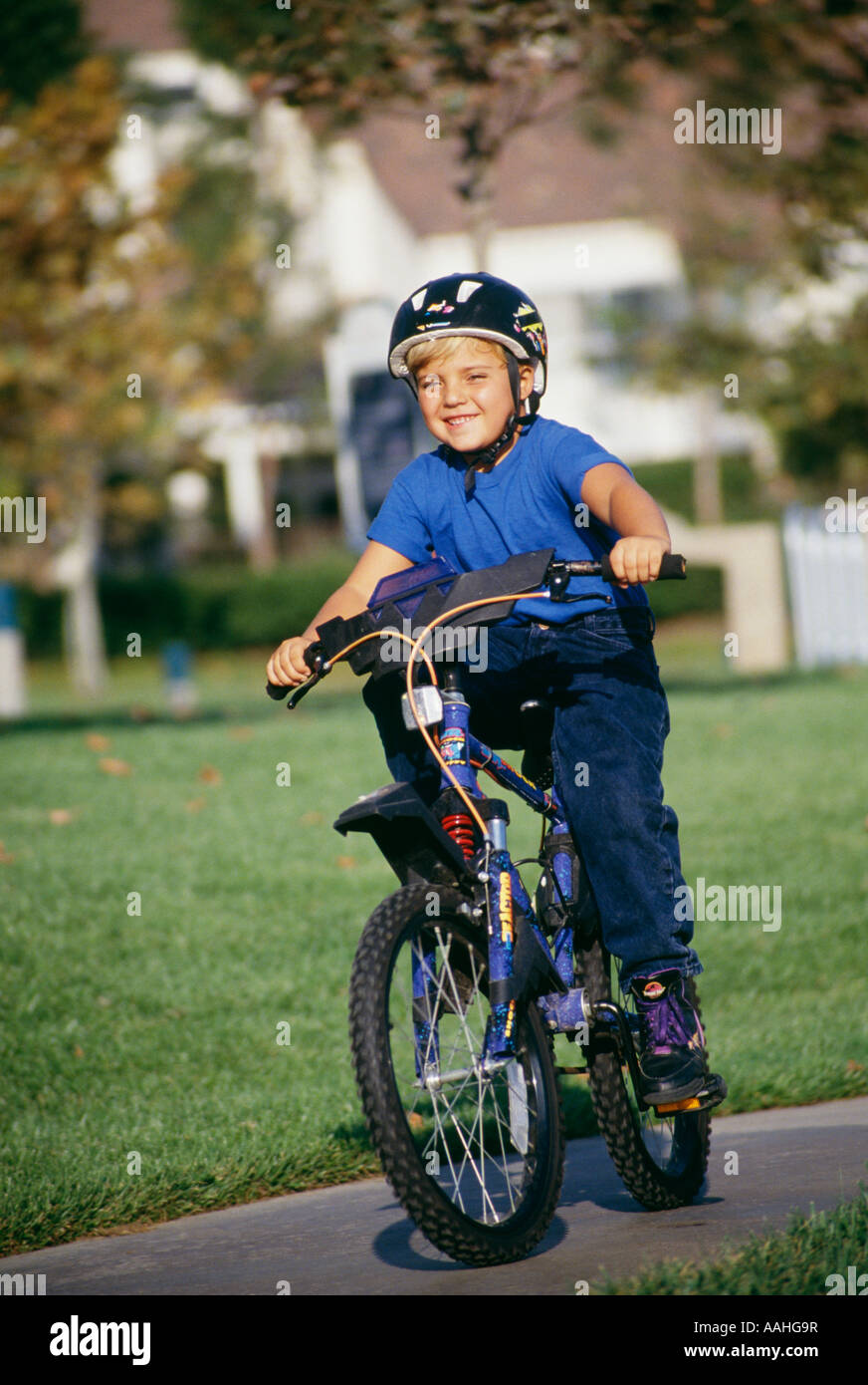 Child children  Boy 6 7 years year old riding bicycle bicycles bike bikes United States outside activity active exercise exercises exercising Stock Photo