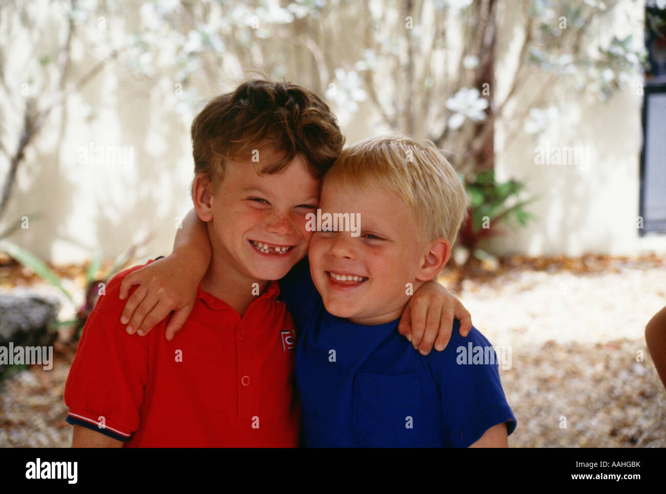 Boys 4 7 with arms around smiling portrait Stock Photo - Alamy
