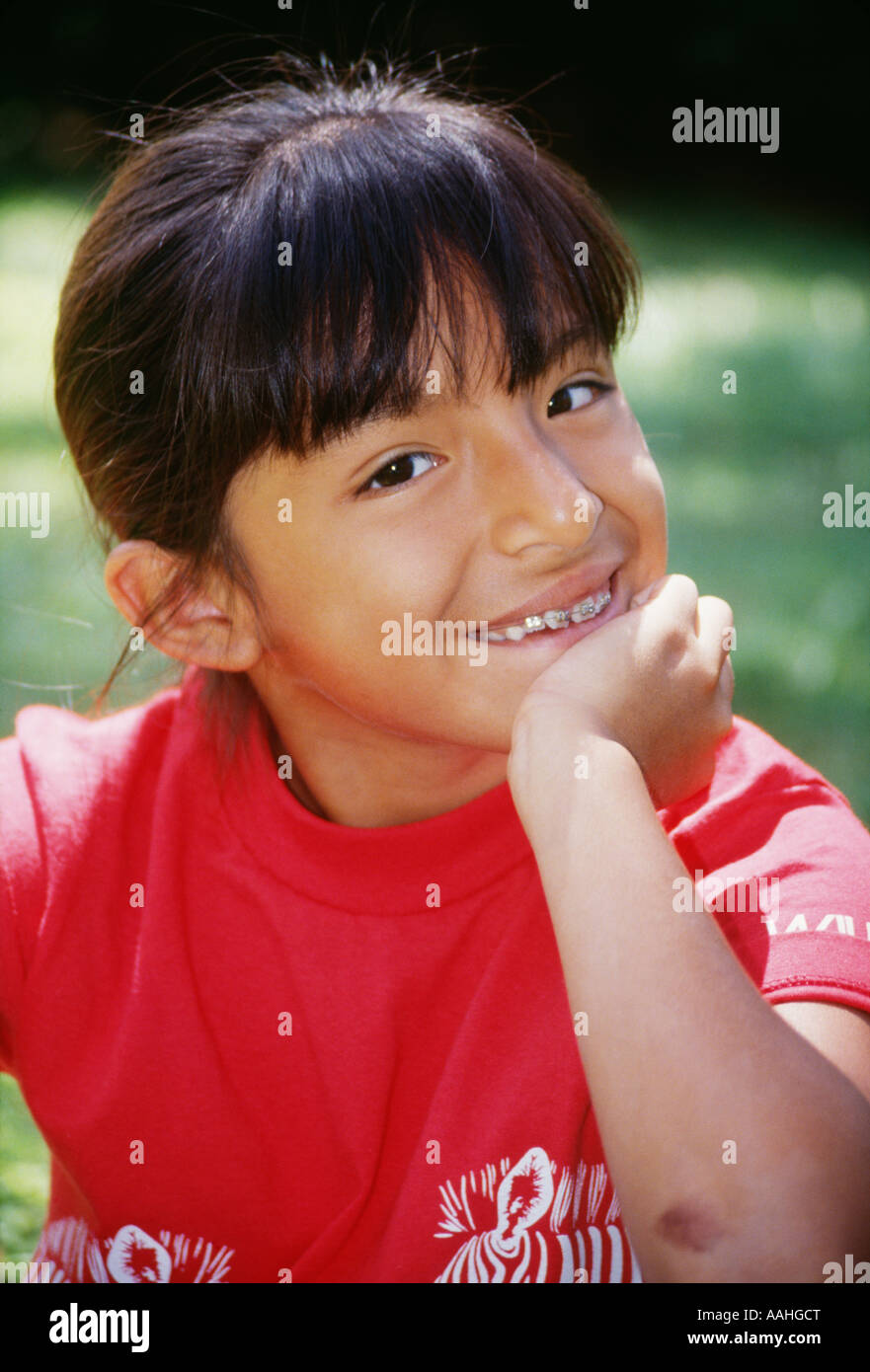 Happy Hispanic asian 7-9 year old smiling portrait wearing braces teeth closeup multicultural multi racial cultural biracial eye contact MR © Myrleen Pearson Stock Photo