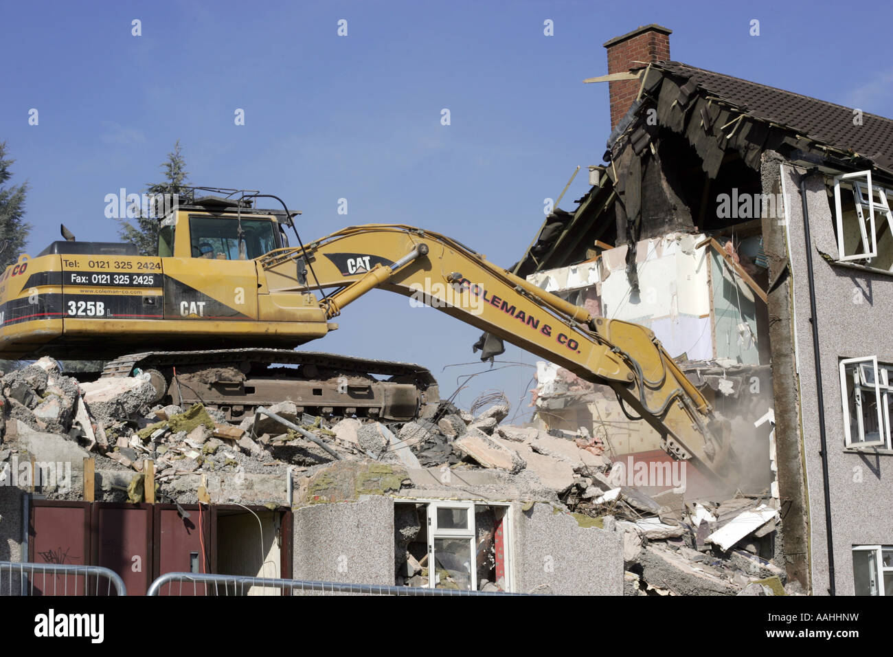 A bulldozer demolishing old council houses in Ley Hill, Northfield, Birmingham, England. Stock Photo