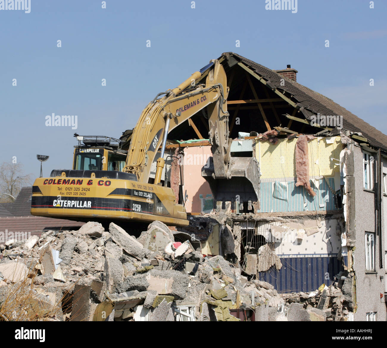 Demolition. A bulldozer demolishing old council houses in Ley Hill, Northfield, Birmingham, England. Stock Photo