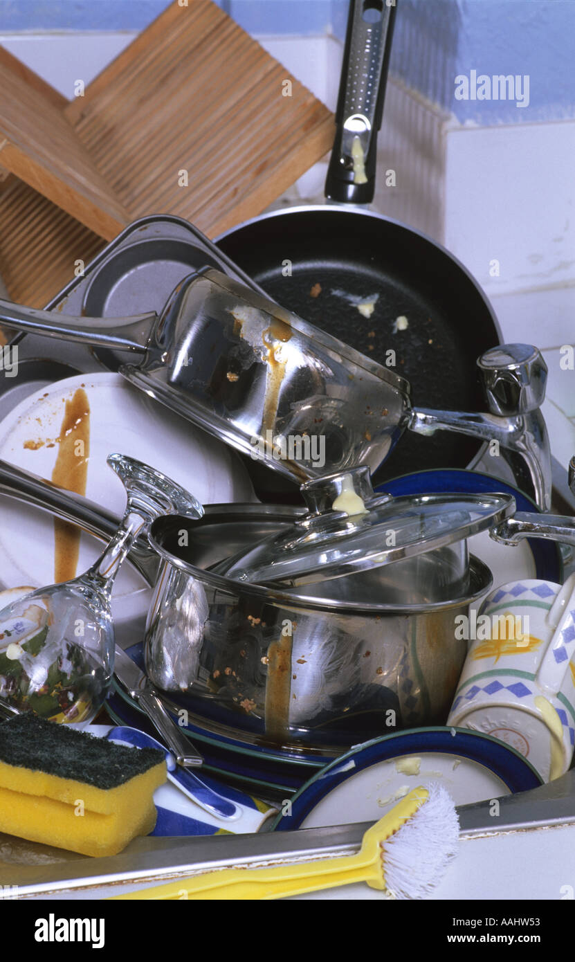 giant mound of dirty washing up left in kitchen sink in house Stock Photo