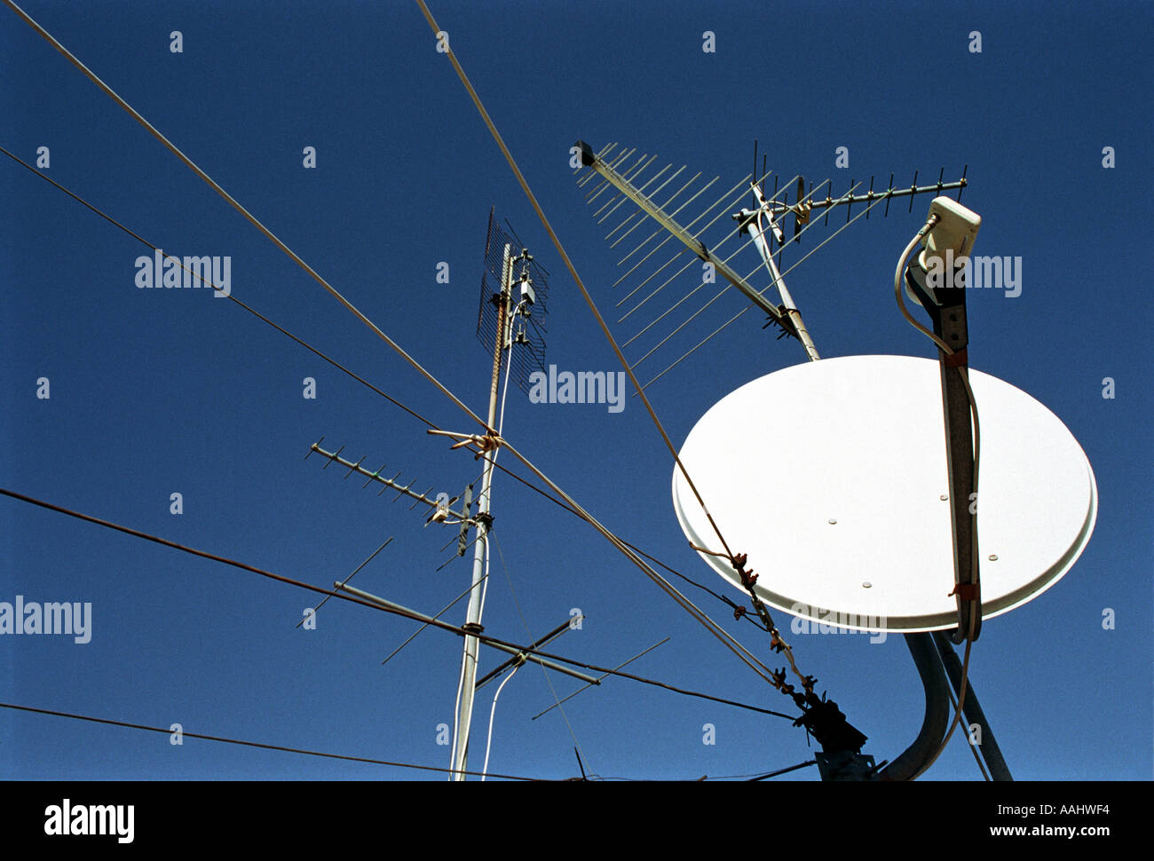 satellite dish receiver and aerials and cables and blue sky Stock Photo