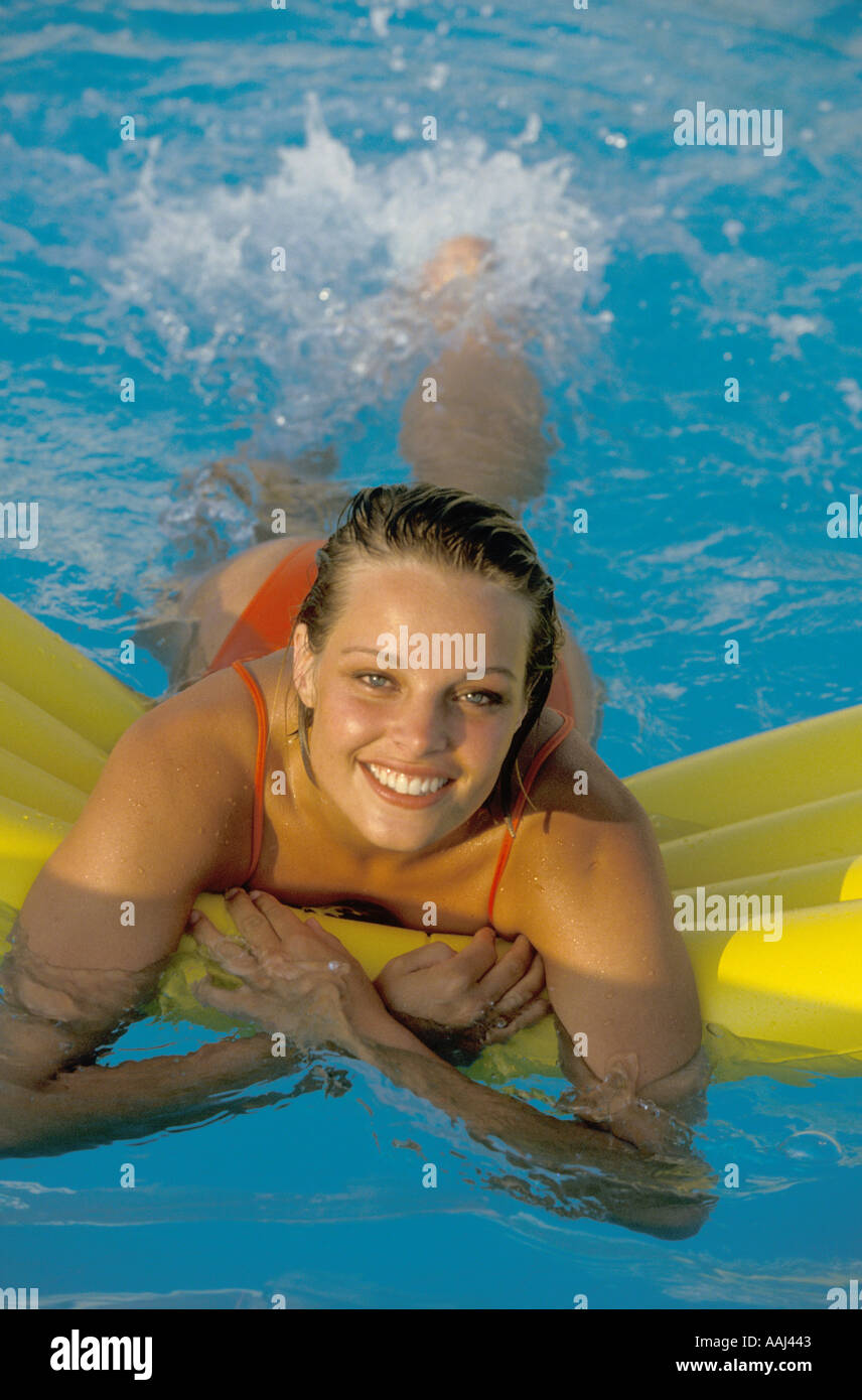 young woman on airbed in pool Stock Photo
