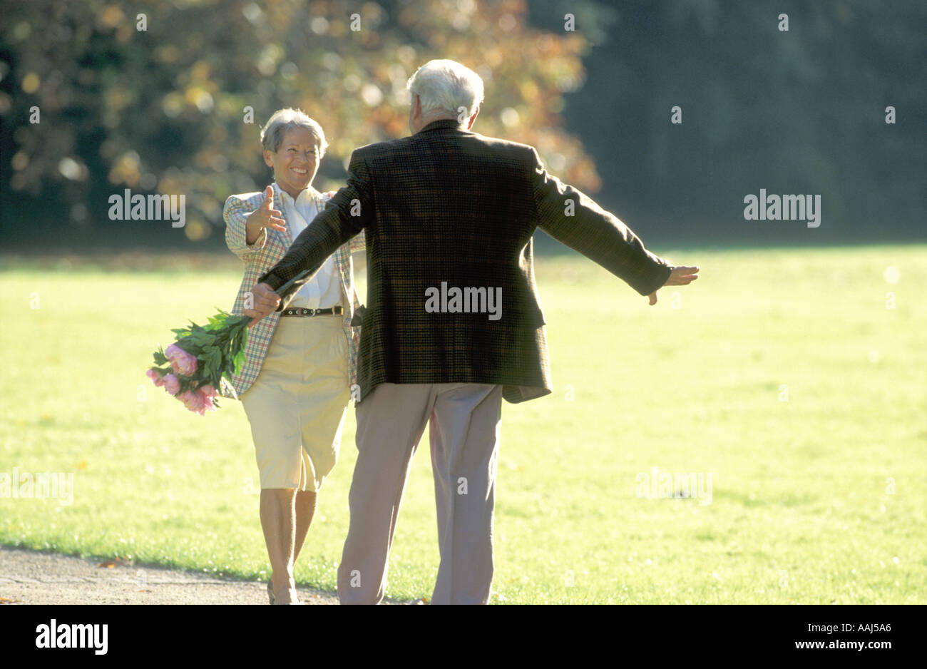 elderly couple dancing in park Stock Photo