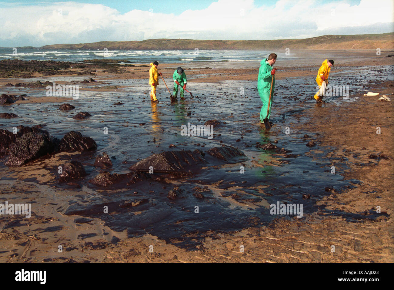 Workmen clean up oil pollution from Sea Empress tanker on beach at