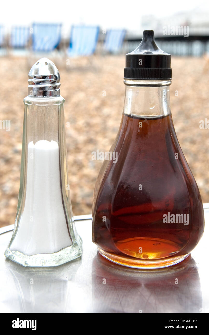 Salt and vinegar containers on a table beside the sea Stock Photo