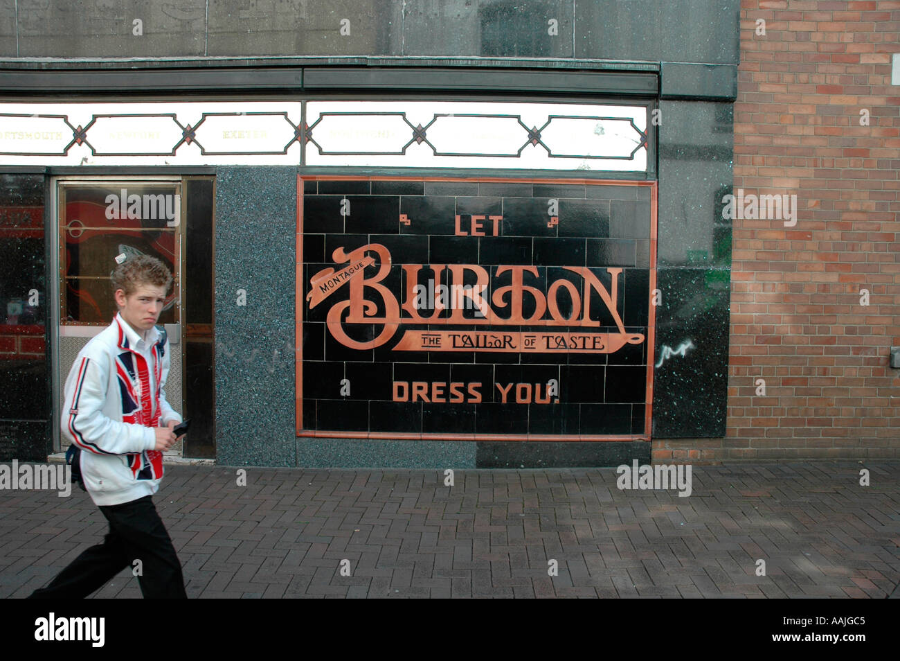 Teenager walking past sign outside Burtons shop Abergavenny Wales Stock Photo