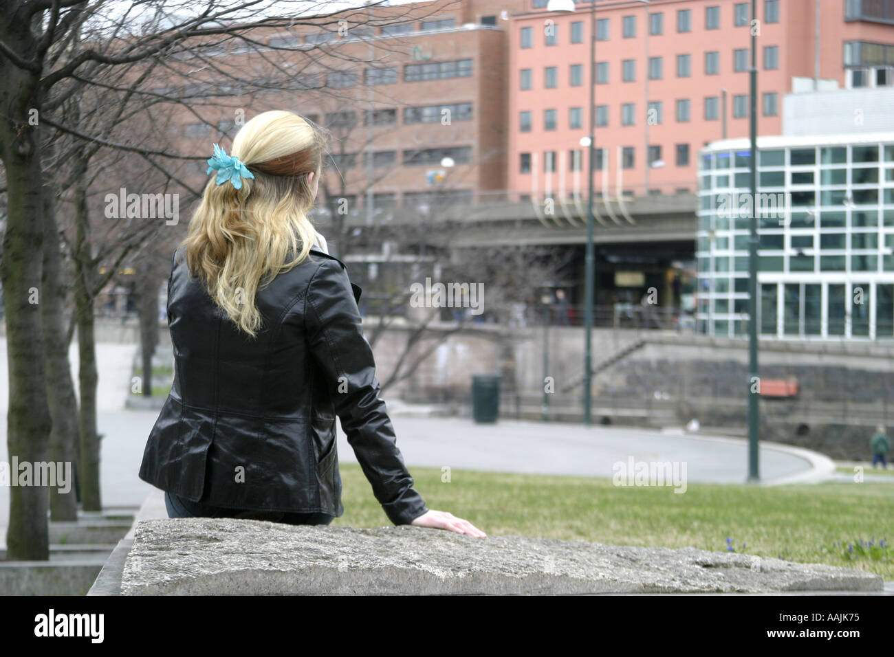 Young woman viewed from behind sitting in a park Stock Photo - Alamy