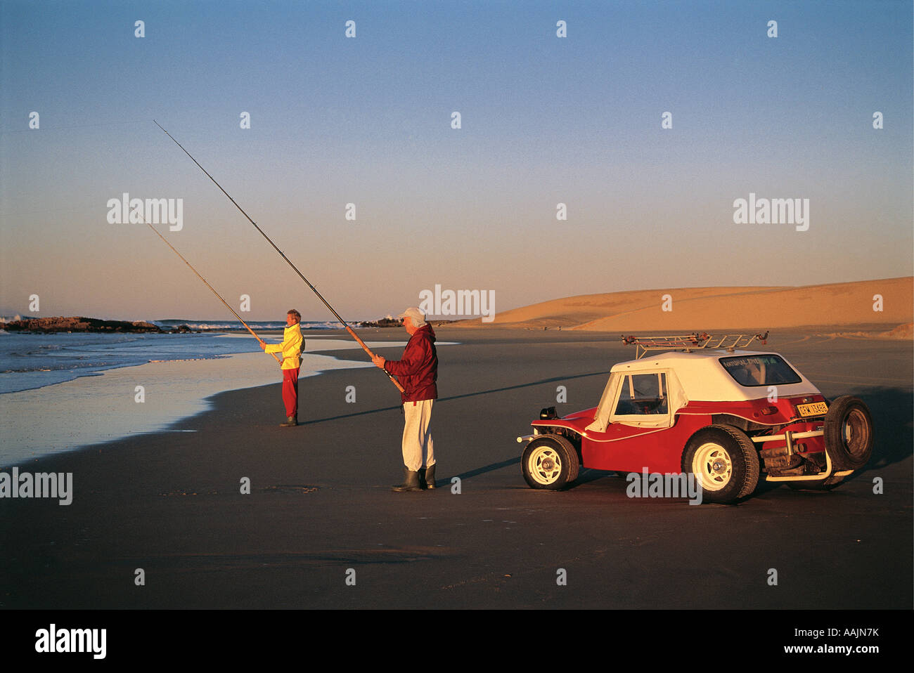 Two anlgers Rod Fishing at Kaizer Beach near East London Eastern Cape South Africa A red beach buggy car is parked close by Stock Photo