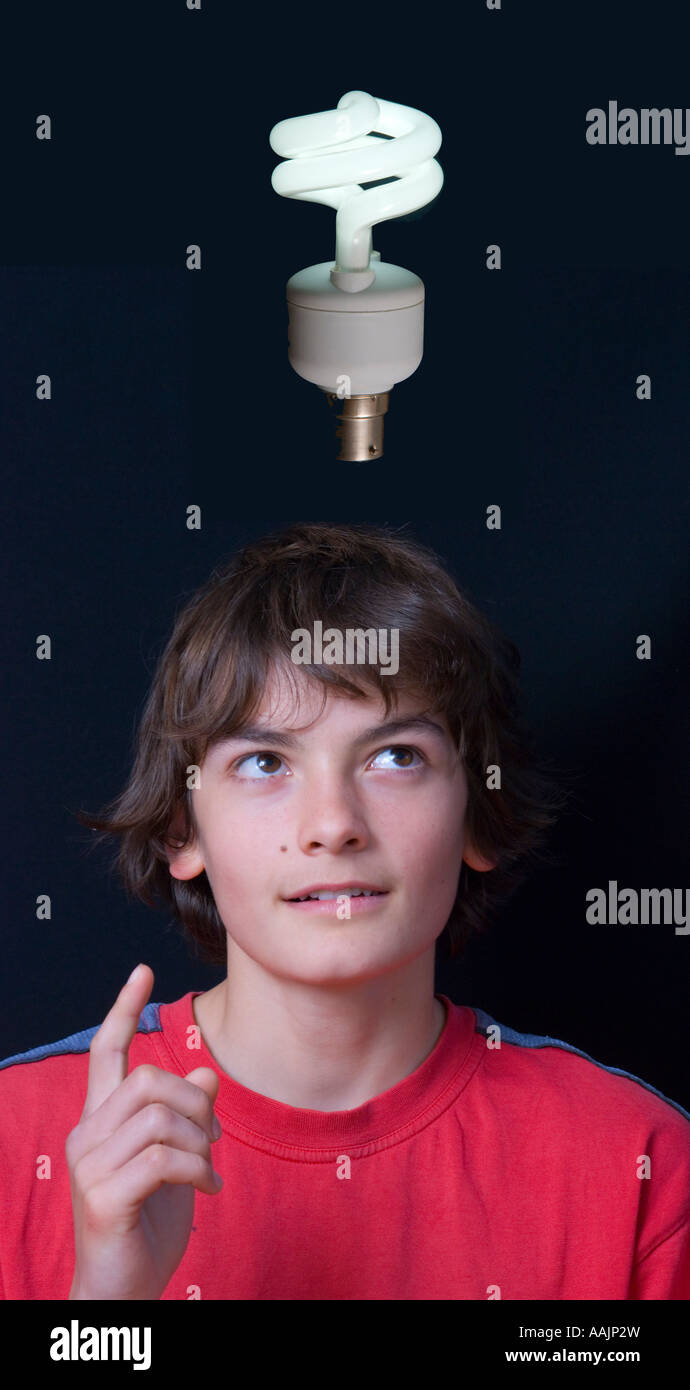 Young boy looking up with a low energy lamp over his head against a