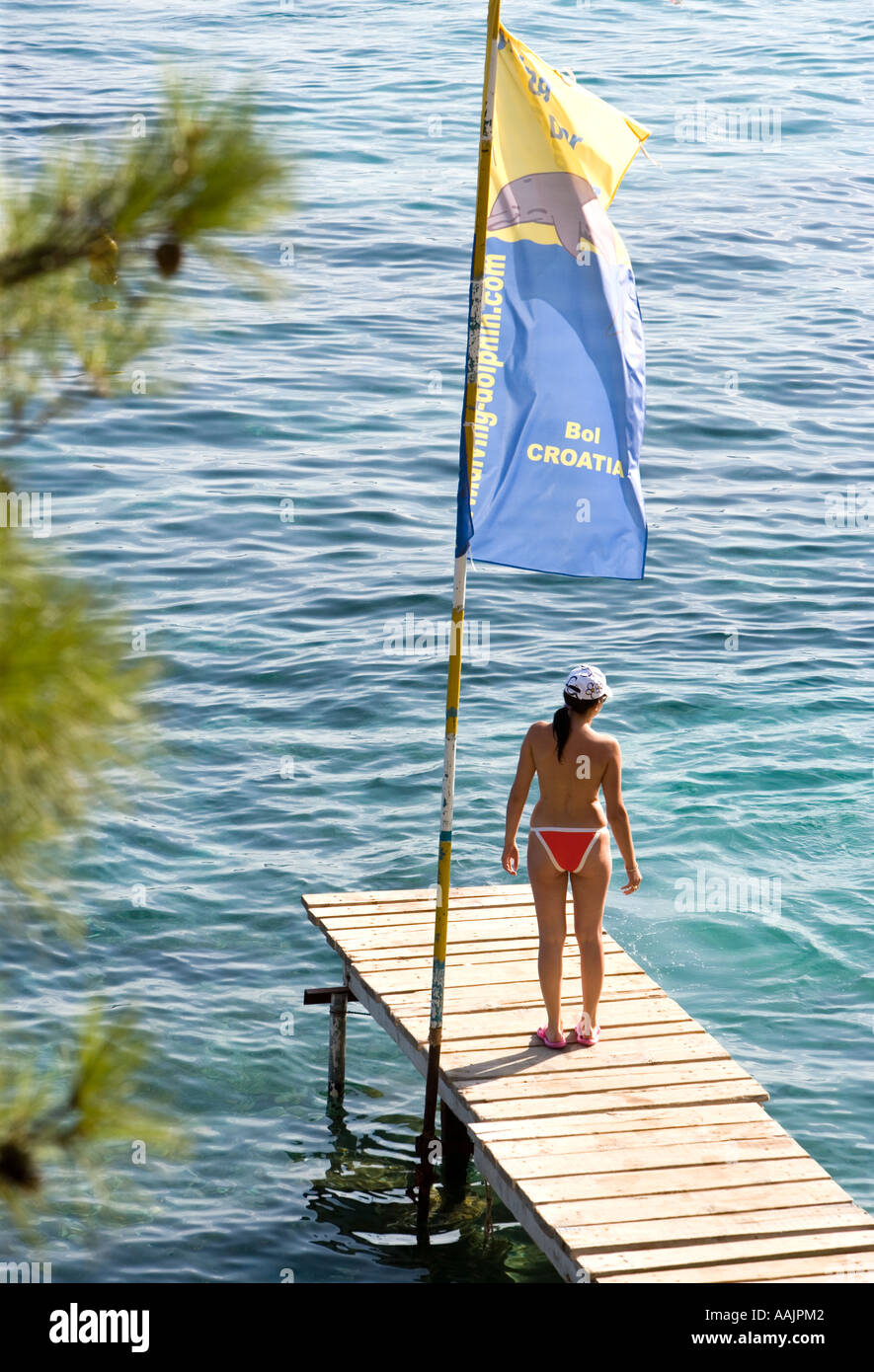 Woman without bikini top looking out to sea at Bol Croatia Stock Photo -  Alamy