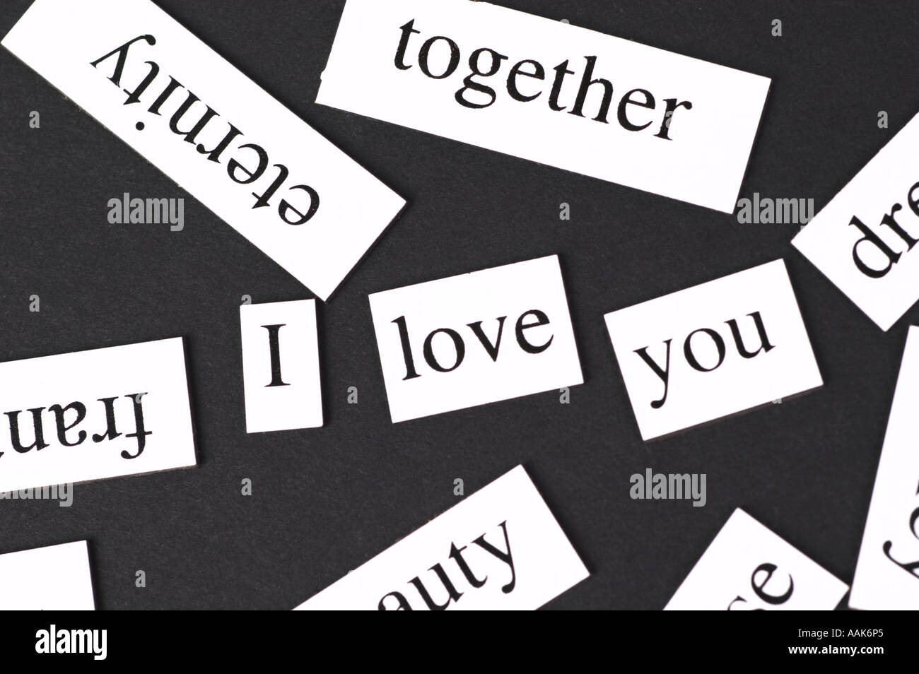 Magnetic fridge words jumbled up but with the words I Love You in the middle Stock Photo